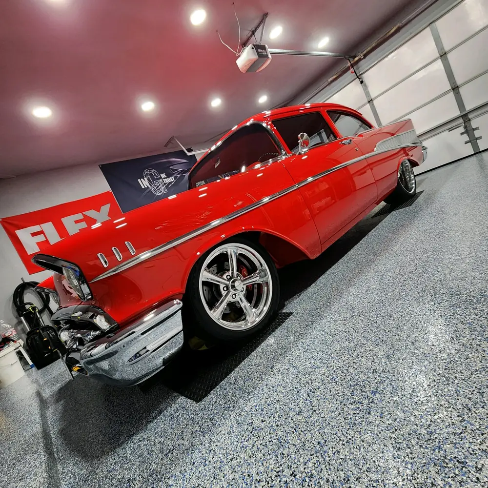 A freshly detailed red 1957 Chevrolet gleaming inside the Cars N Things shop in La Quinta